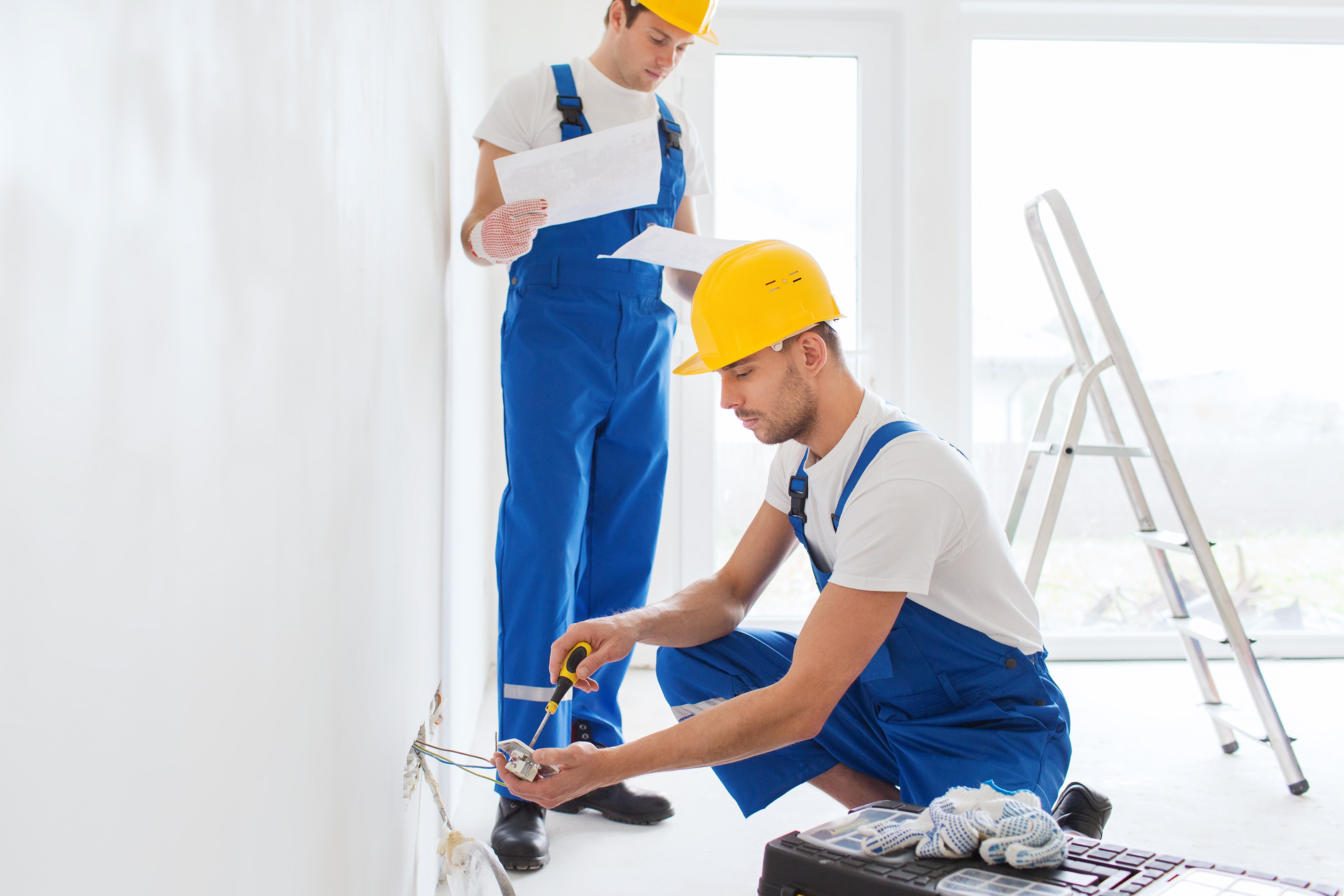 builders with tablet pc and equipment indoors